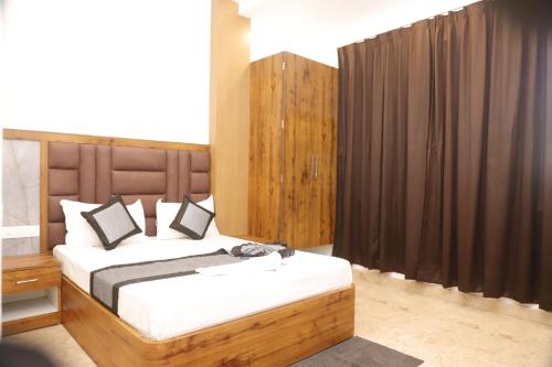 a bedroom with a large bed with a wooden headboard at The Blessing Palace in Muzaffarpur