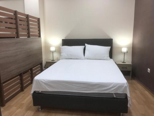 a bedroom with a large bed with white sheets and pillows at Διαμέρισμα στο κέντρο της πόλης in Thiva