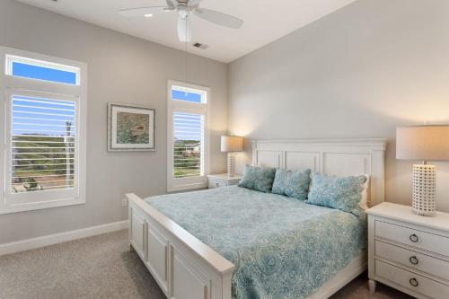 a bedroom with a bed and two windows at 3025 - Who's On First in Southern Shores