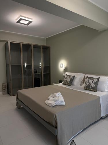 a bedroom with a large bed with towels on it at SunBeach 44 - Luxury B&B in Melito di Porto Salvo