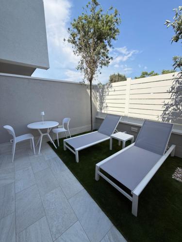 a patio with a table and two chairs and a table at SunBeach 44 - Luxury B&B in Melito di Porto Salvo
