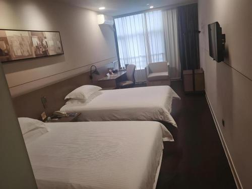 a hotel room with two beds and a window at Jinjiang Inn Select Shanghai Fengxian Baolong Square North Yunhe Road in Shanghai