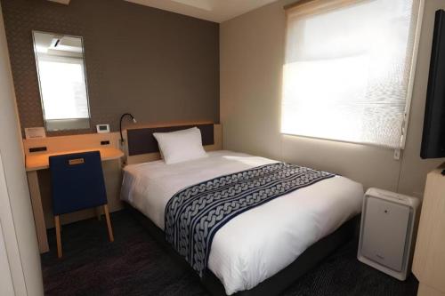 a bedroom with a bed and a desk and window at KEIKYU EX INN Tokyo Nihombashi in Tokyo