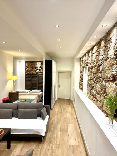 un salon avec un mur en pierre dans l'établissement COCON HYPER CENTRE-VILLE TOUT CONFORT (8), à Ajaccio