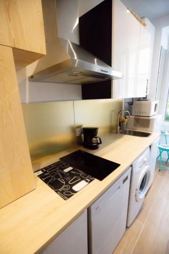 Il comprend une cuisine équipée d'une cuisinière. four supérieur à côté d'un évier dans l'établissement COCON HYPER CENTRE-VILLE TOUT CONFORT (8), à Ajaccio