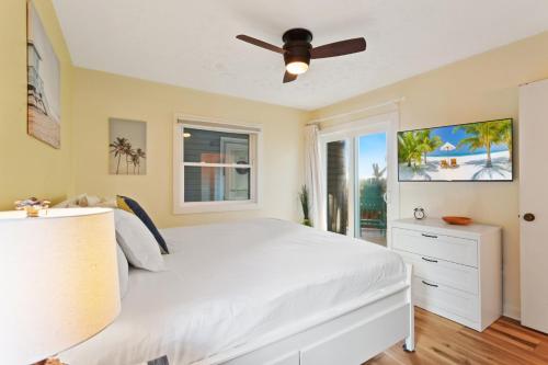 a bedroom with a white bed and a ceiling fan at SO5A - Oceanside Bungalow in Kill Devil Hills