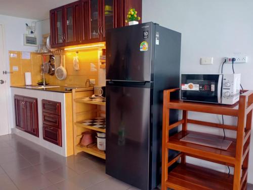 a kitchen with a black refrigerator and a microwave at VIP condochain 24th floor in Ban Phe