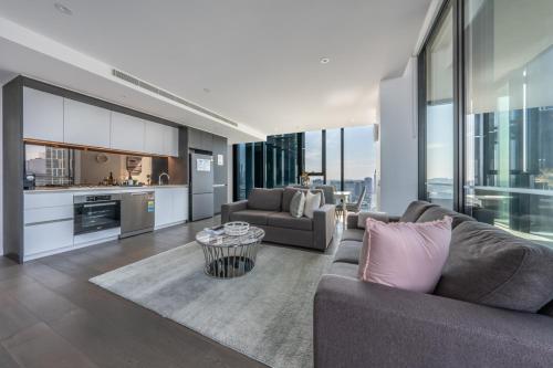 a living room with a couch and a table at Melbourne Corporate Stays - Docklands Waterfront in Melbourne