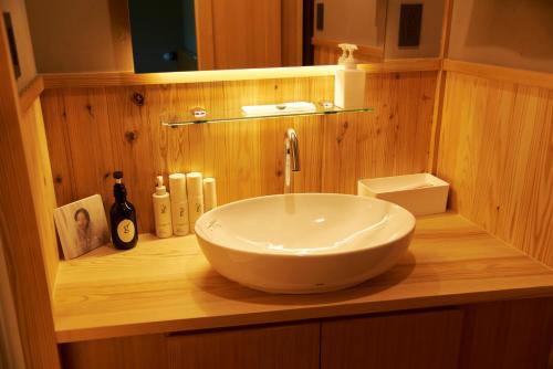 a bathroom with a bowl sink on a wooden counter at Travel Stop UNNOWA in Tomi
