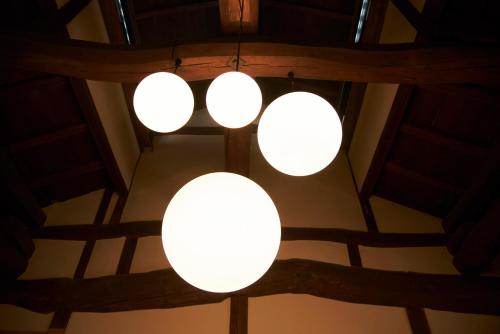 a group of three lights hanging from a ceiling at Travel Stop UNNOWA in Tomi