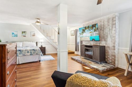 a living room with a fireplace and a bed at 5047 - Sandy Cove OBX in Kill Devil Hills