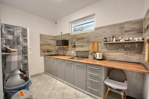 a kitchen with gray cabinets and a sink and a window at willa wena in Krynica Zdrój