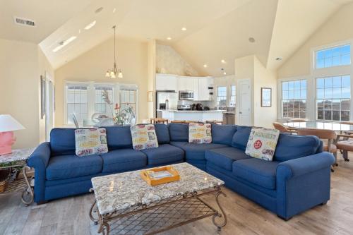 a living room with a blue couch and a table at 8046 - Sun Runner in Rodanthe