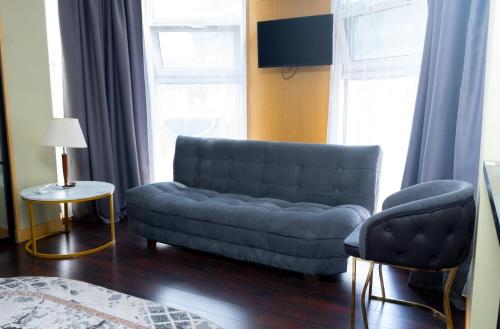 a living room with a blue couch and two chairs at Arnas hotel in Almaty