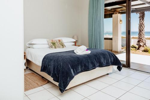 a bedroom with a bed and a view of the ocean at Khayanoster in Paternoster