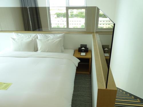 a hotel room with a bed and a mirror at Hound Hotel Busan Station in Busan