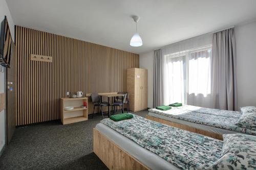 a hotel room with two beds and a table at willa wena in Krynica Zdrój