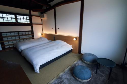 a bedroom with a white bed and two tables at Travel Stop UNNOWA in Tomi