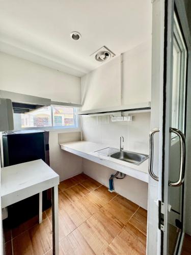 a small kitchen with white cabinets and a sink at Chaweng Eco Parc in Ban Ko Khwan