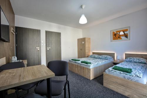 a room with two beds and a table and chairs at willa wena in Krynica Zdrój