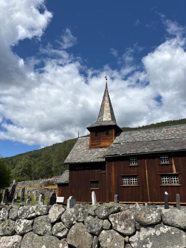 a large wooden building with a tower on top of a stone wall at Geilo, two cabins, silence, nature, skiing and summer sports in Geilo