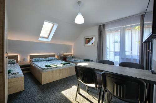 a bedroom with two beds and a table and chairs at willa wena in Krynica Zdrój