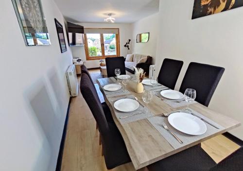 a dining room table with black chairs and a wooden table and chairsktop at Dundee Beach Villa with Free Parking in Dundee