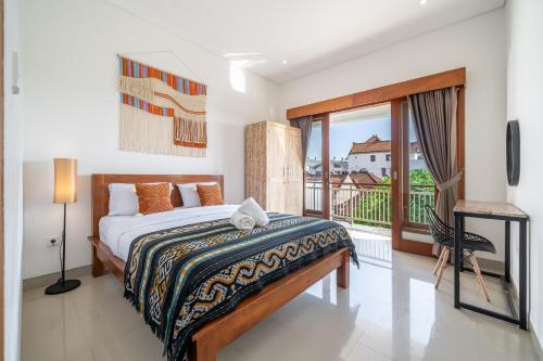 une chambre avec un lit et un balcon dans l'établissement Maha Villas, à Canggu