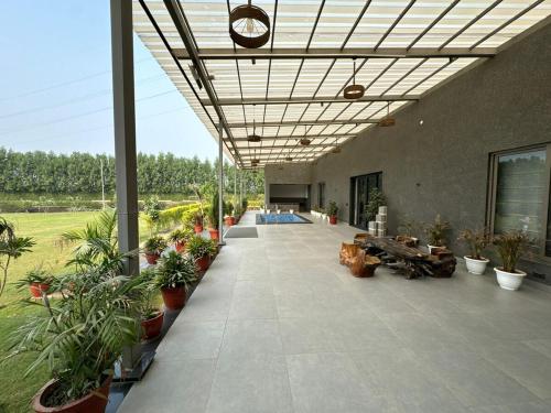 a large building with plants and a patio at Arzen Farms in Zirakpur