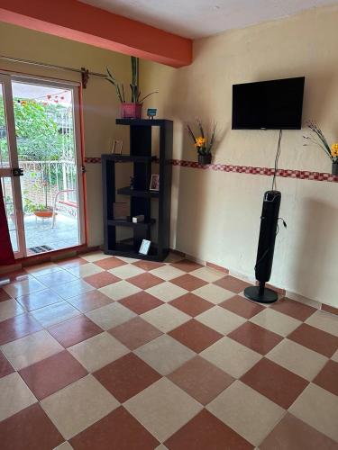 ein Wohnzimmer mit Schachbrettboden und einem Flachbildfernseher in der Unterkunft Spacious Apartment with Terrace in Orizaba