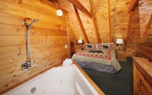 a bedroom with a bed and a tub in a cabin at Brink of Paradise in Gatlinburg