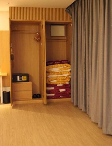 a room with a closet with a curtain and a bed at Hotel Dongbang in Jinju