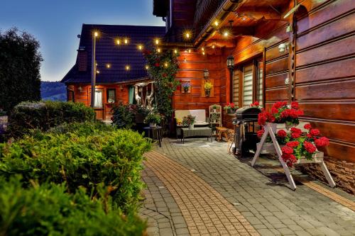 a patio of a house with flowers and lights at Domek i Pokoje z widokiem na Tatry - U Magdy Zakopane in Zakopane