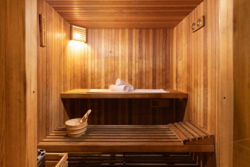 a wooden sauna with a wooden bench in it at Comfort Hotel and Spa - Adults Only in Eilat