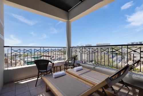 a balcony with a hammock and a table and chairs at Comfort Hotel and Spa - Adults Only in Eilat