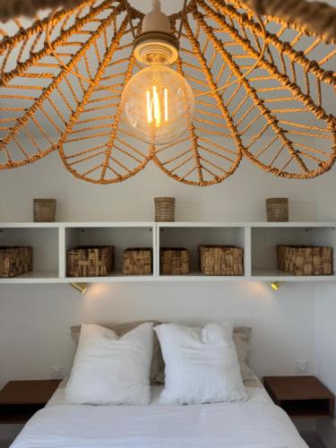 a large chandelier above a bed with white pillows at La Grande Tour in Valras-Plage