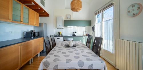 une cuisine avec une table et une cuisine avec une table et des chaises dans l'établissement SAURET : Havre de paix en ville : spacieux et confortable, à Montpellier