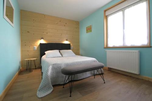 1 dormitorio con 1 cama en una habitación con paredes azules en Gîte de groupe Le Clos du Sapin Bleu à Saint-Dié-des-Vosges, Nature&Convivialité, en Saint-Dié-des-Vosges