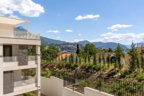 a view from the balcony of a house with mountains in the background at Hi Montenegro - RiverSide Apartment in Igalo