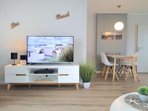 a living room with a television on a white dresser at Haffblick Whg Ha16 in Boltenhagen