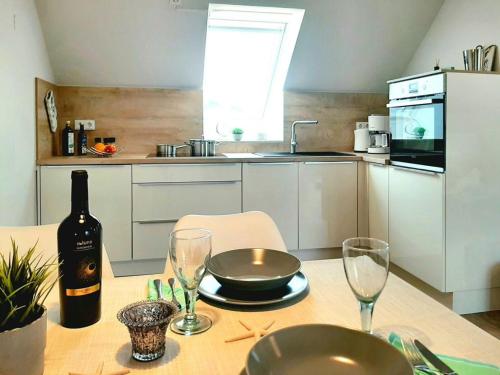 a kitchen with a table with a bottle of wine and glasses at Haffblick Whg Ha16 in Boltenhagen