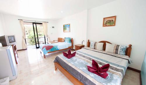 a living room with two beds and a television at Lotus Friendly Hotel in Chaweng