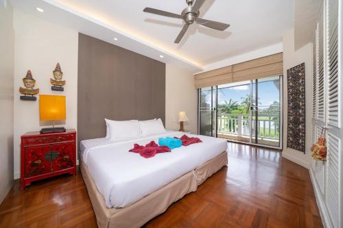 une chambre avec un grand lit blanc et une fenêtre dans l'établissement Stylish Thai 2BR Condo Pool & Golf with Balcony, à Laguna Phuket