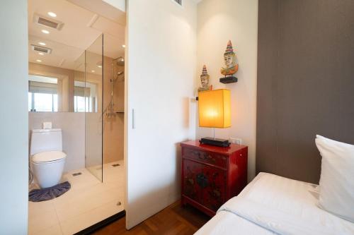 une chambre avec une douche, un lit et une lampe dans l'établissement Stylish Thai 2BR Condo Pool & Golf with Balcony, à Laguna Phuket