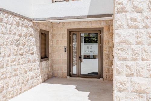 a glass door of a building with a sign on it at Hi Montenegro - RiverSide Apartment in Igalo