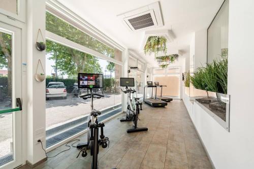 a gym with treadmills and exercise bikes in a hallway at tecnopolo aparthotel in Bologna