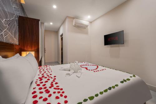 a bed with red rose petals on it at KLY Hotel Vung Tau in Vung Tau