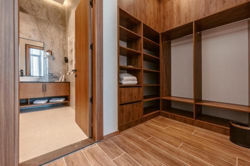a bathroom with wooden cabinets and a door leading to a sink at Kass Diamond Resort in Tsalka