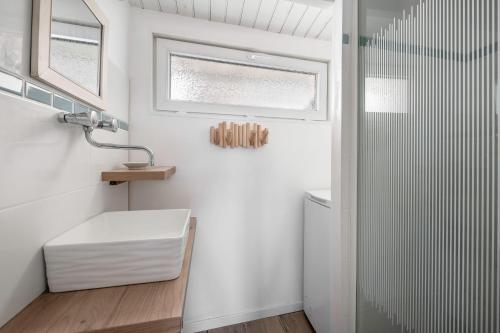 a white bathroom with a shower and a sink at Maison à 50m de la mer, 4 adultes et 2 enfants in La Richemondière