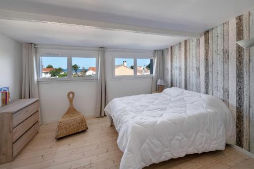 a white bedroom with a large bed and two windows at Maison à 50m de la mer, 4 adultes et 2 enfants in La Richemondière